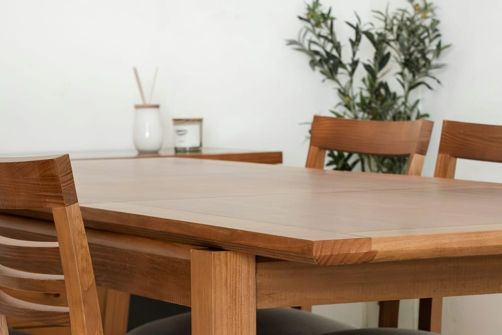 Een houten eettafel met een rechte rand en stoelen
